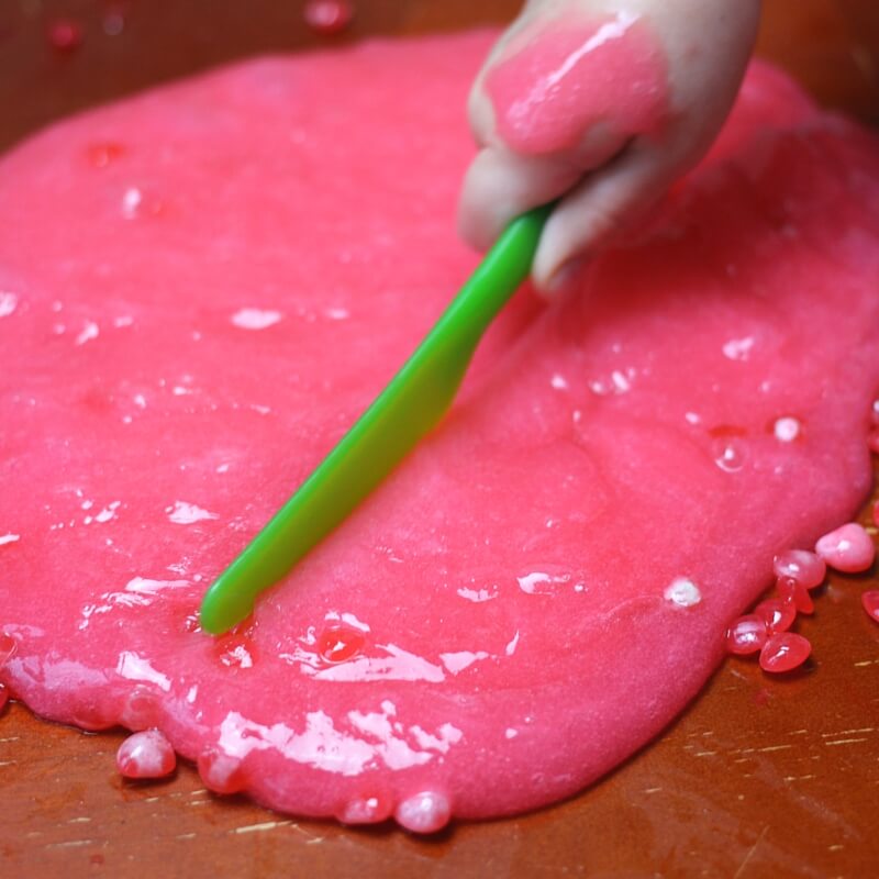 Cutting valentine's day slime - adding tools to sensory play is a great way to prolong interest